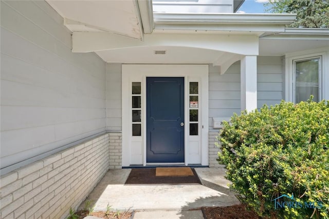view of exterior entry featuring brick siding