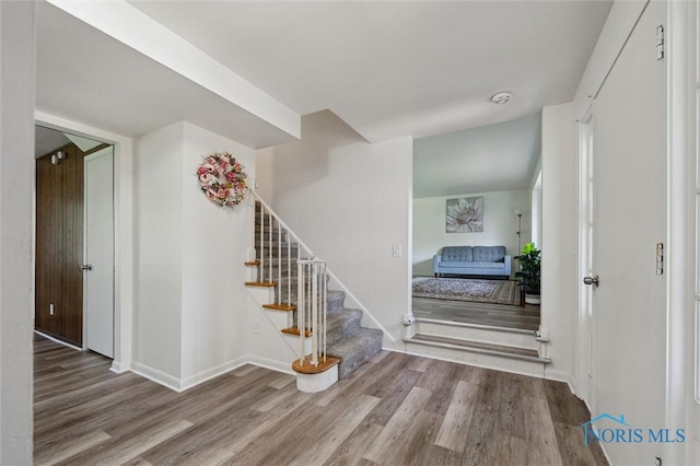 entrance foyer with baseboards, stairs, and wood finished floors