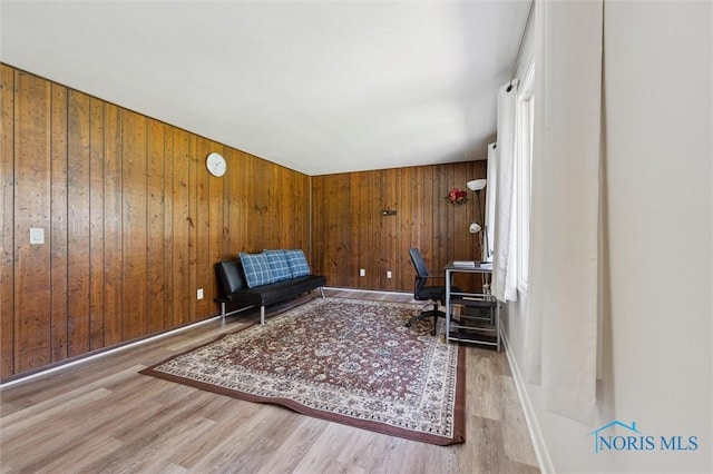 living area with wood walls and wood finished floors