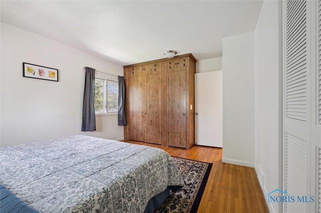 bedroom with light wood-style floors, baseboards, and visible vents