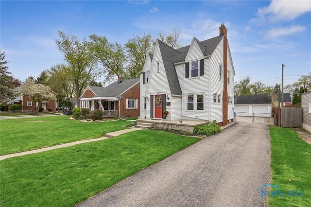1805 Heatherdowns Blvd, Toledo, OH 43614 - view of front of house with a chimney, a garage, an outdoor structure, and a shingled roof