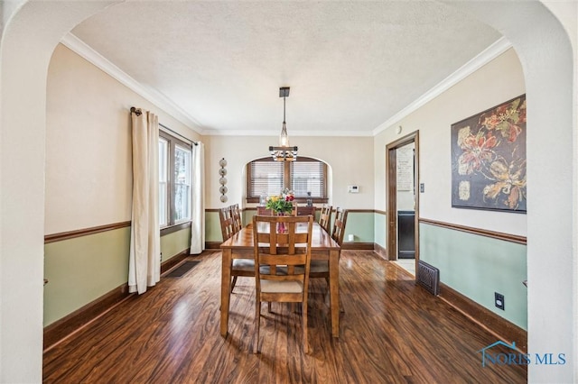 1805 Heatherdowns Blvd, Toledo, OH 43614 - dining room with dark wood finished floors, arched walkways, a chandelier, ornamental molding, and baseboards