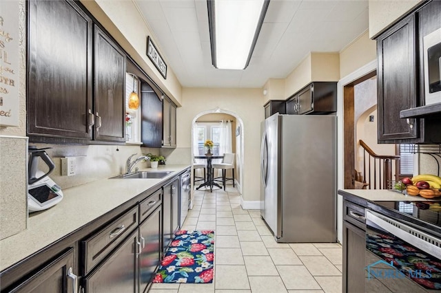 1805 Heatherdowns Blvd, Toledo, OH 43614 - kitchen with freestanding refrigerator, arched walkways, a sink, light tile patterned floors, and dark brown cabinets