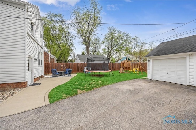 1805 Heatherdowns Blvd, Toledo, OH 43614 - view of yard with a trampoline, a playground, driveway, a patio, and a garage