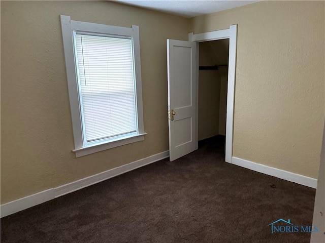 1012 Alden Ct, Toledo, OH 43609 - unfurnished bedroom featuring dark colored carpet, baseboards, and a closet