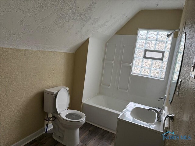 1012 Alden Ct, Toledo, OH 43609 - full bath with a textured wall, vaulted ceiling, toilet, and wood finished floors