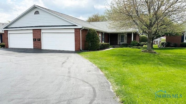 ranch-style home featuring driveway, a front yard, brick siding, and a garage