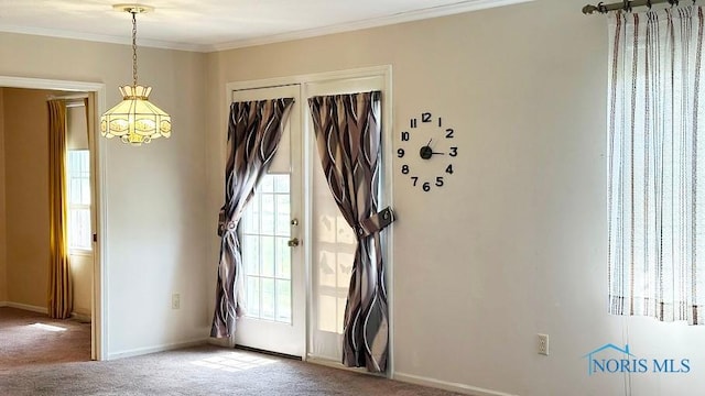 entryway with an inviting chandelier, ornamental molding, a healthy amount of sunlight, and carpet flooring