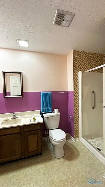 bathroom with visible vents, a shower stall, a textured ceiling, and vanity