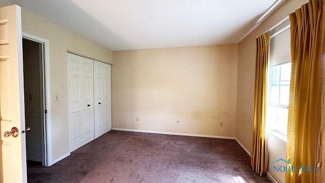 unfurnished bedroom featuring a closet, carpet, and baseboards
