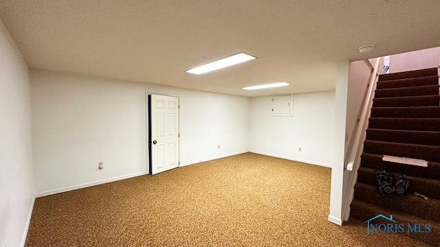 finished basement featuring baseboards, stairway, a textured ceiling, and carpet