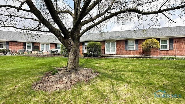view of front of home with brick siding and a front lawn
