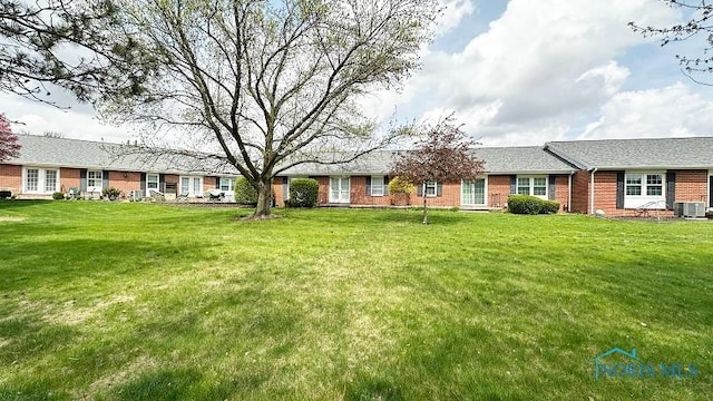 single story home featuring a front lawn, central AC, and brick siding