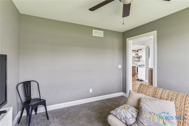 living area with carpet floors, a ceiling fan, baseboards, and visible vents