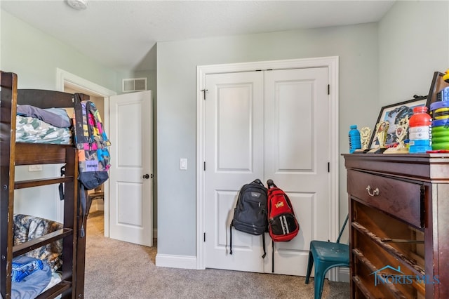 bedroom with visible vents, carpet floors, and a closet