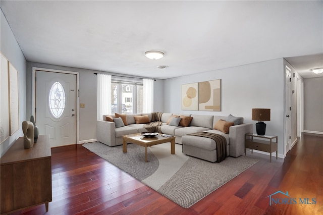 living area featuring baseboards and dark wood finished floors