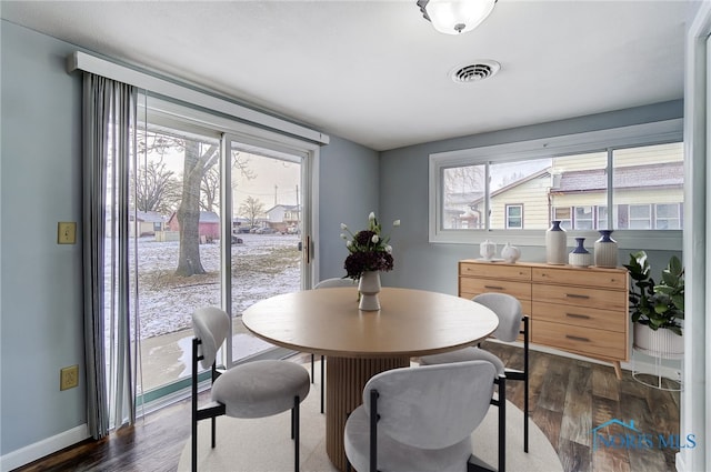 dining room with baseboards, visible vents, dark wood-style floors, and a wealth of natural light