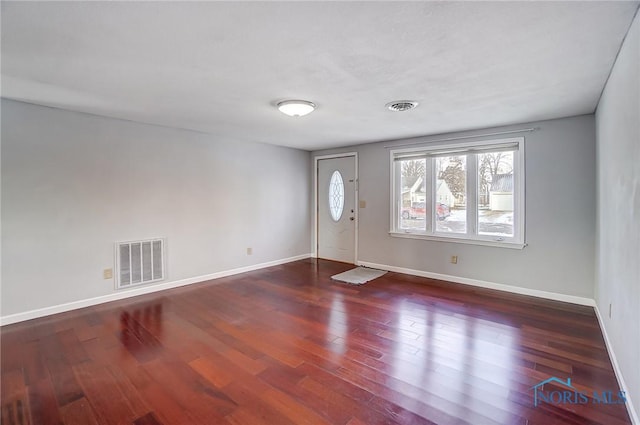 interior space with baseboards, visible vents, and wood finished floors