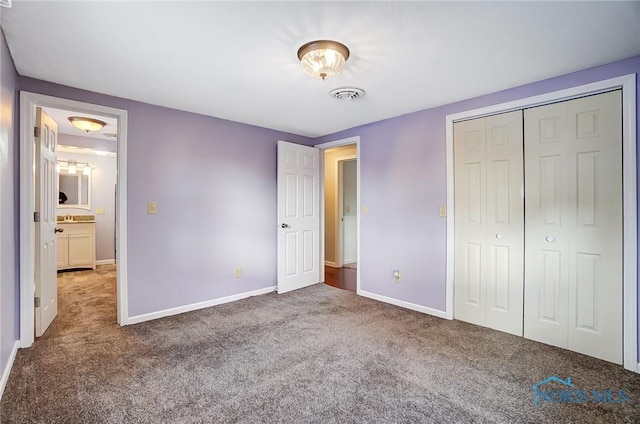 unfurnished bedroom with carpet floors, baseboards, a closet, and visible vents