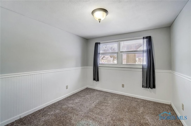 carpeted empty room featuring baseboards