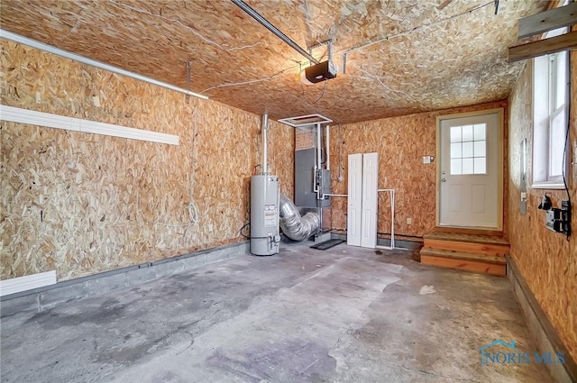 garage featuring heating unit, a garage door opener, and gas water heater