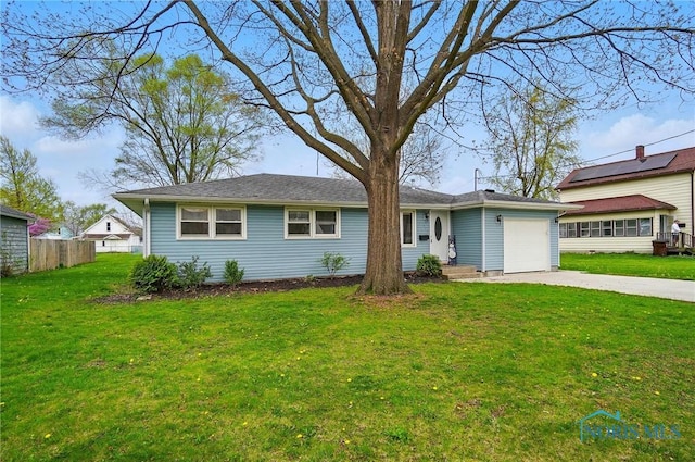 view of front of home featuring concrete driveway, fence, a front yard, and a garage