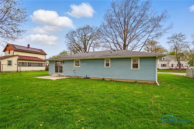 rear view of house with a lawn and a patio
