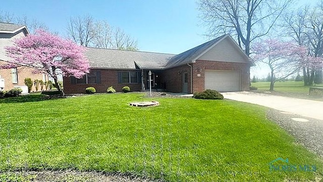 ranch-style home featuring a front yard, driveway, an attached garage, and brick siding