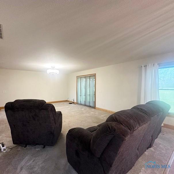 carpeted living room with visible vents and baseboards