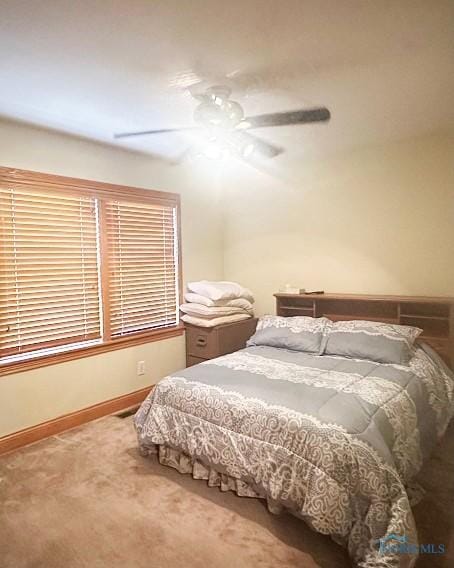 bedroom with a ceiling fan, carpet flooring, and baseboards