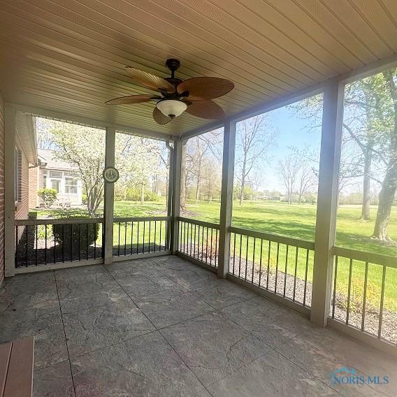 unfurnished sunroom featuring a ceiling fan