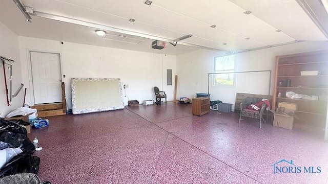 garage with a garage door opener and electric panel