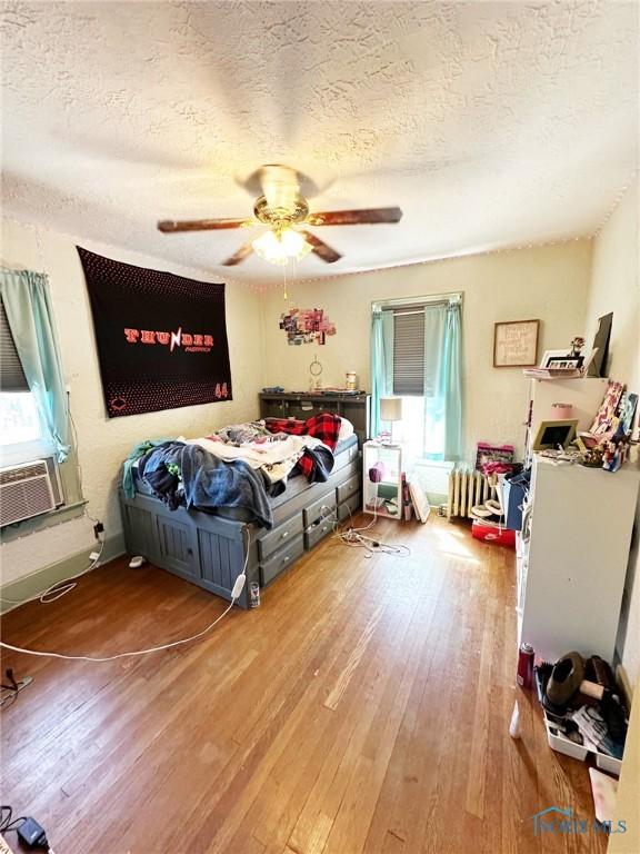 399 Melmore St, Tiffin, OH 44883 - bedroom with a textured ceiling, ceiling fan, cooling unit, and wood-type flooring