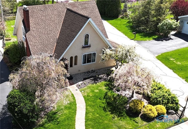 399 Melmore St, Tiffin, OH 44883 - view of home's exterior with a lawn, stucco siding, and roof with shingles