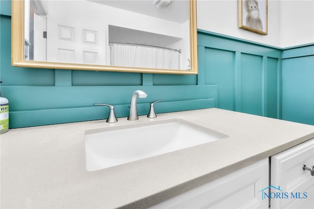 bathroom with a decorative wall and vanity