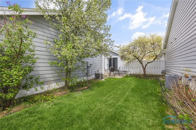 view of yard featuring fence, central air condition unit, and a patio