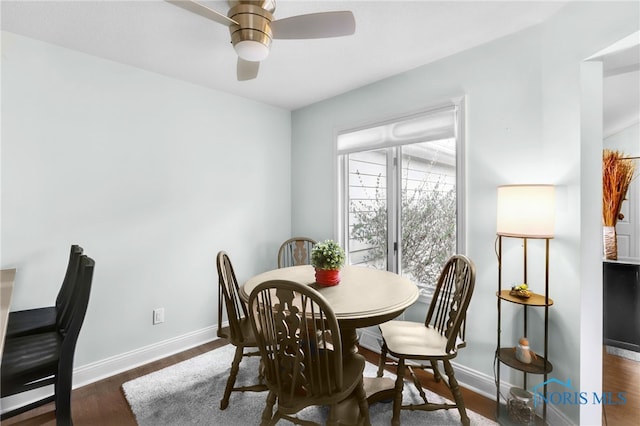 dining space featuring baseboards, wood finished floors, and ceiling fan