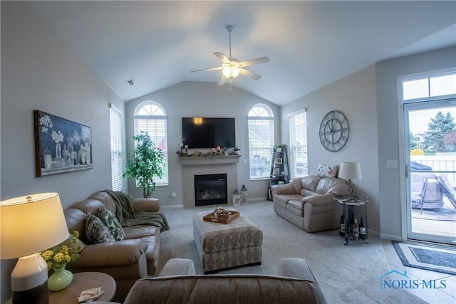 carpeted living room with a ceiling fan, baseboards, lofted ceiling, and a tile fireplace