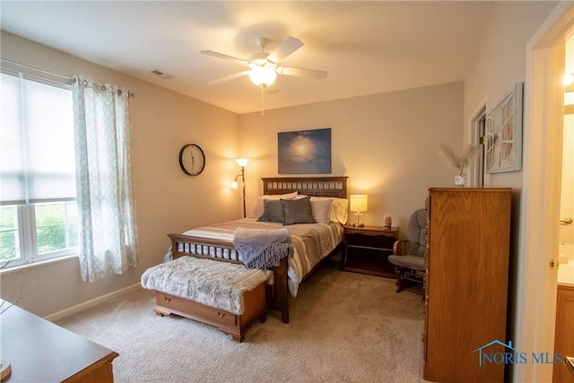 bedroom with a ceiling fan, baseboards, visible vents, and light carpet