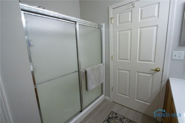 bathroom featuring wood finished floors and a stall shower