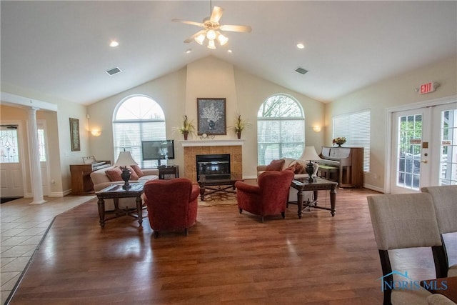 living area with ornate columns, visible vents, a healthy amount of sunlight, and lofted ceiling