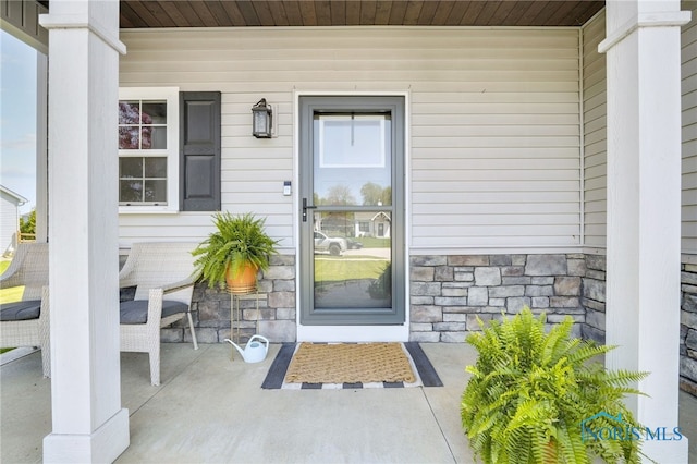 property entrance with covered porch and stone siding