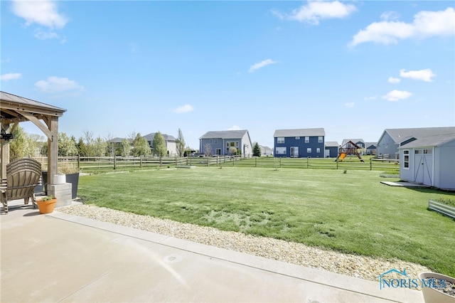 surrounding community featuring a residential view, a gazebo, a fenced backyard, a playground, and a yard