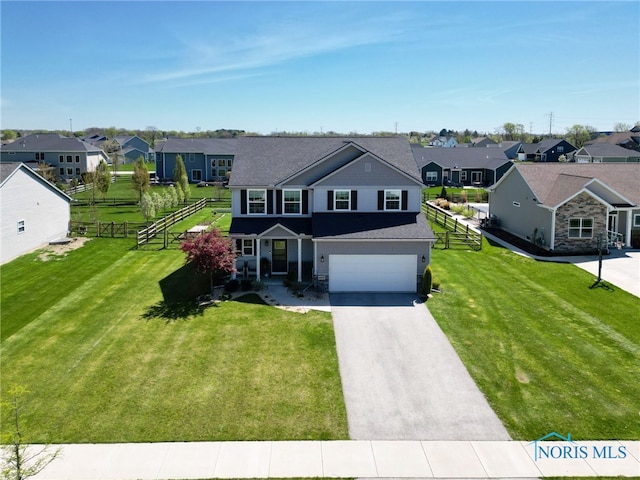 traditional home with a residential view, fence, an attached garage, and aphalt driveway
