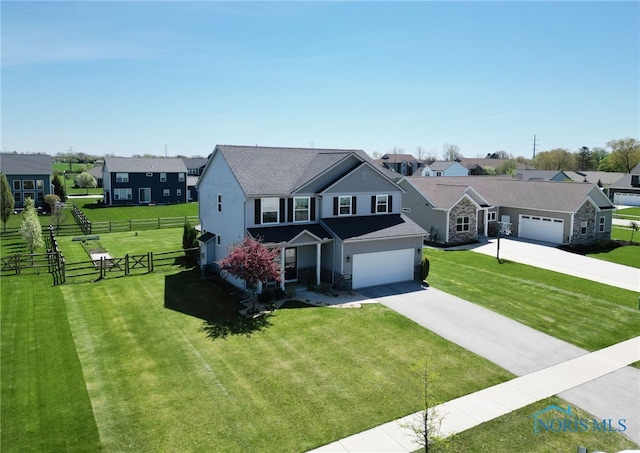 view of front of property featuring a residential view, fence, a front lawn, stone siding, and concrete driveway