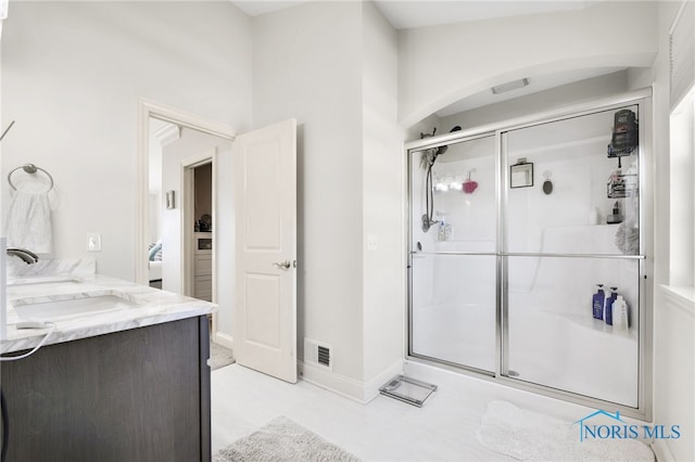 full bath with visible vents, baseboards, vanity, and a shower stall