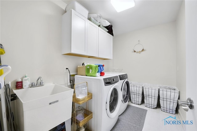 laundry area with a sink, cabinet space, light tile patterned floors, and washer and clothes dryer
