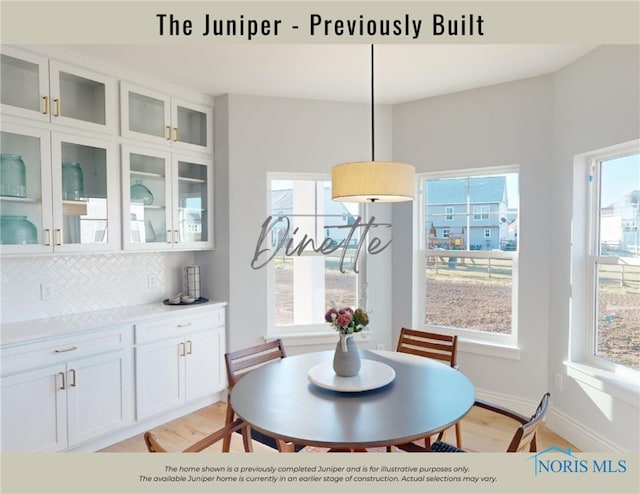 dining area featuring baseboards and light wood-style flooring