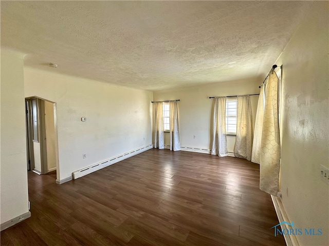 4865 296th St, Toledo, OH 43611 - empty room featuring a baseboard heating unit, dark wood-style floors, and a textured ceiling