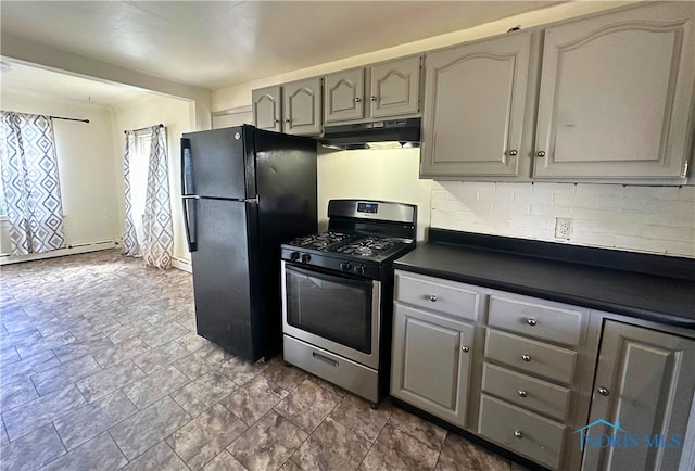 4865 296th St, Toledo, OH 43611 - kitchen featuring dark countertops, under cabinet range hood, gray cabinetry, freestanding refrigerator, and gas range